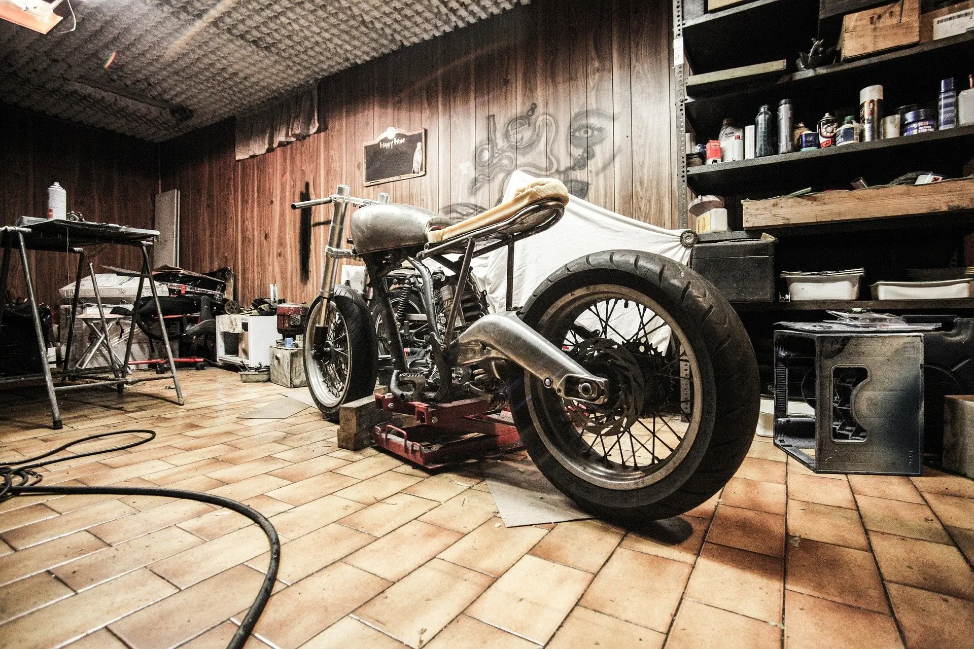 A motorcycle up on a lift inside the RR Bike Repairs workshop